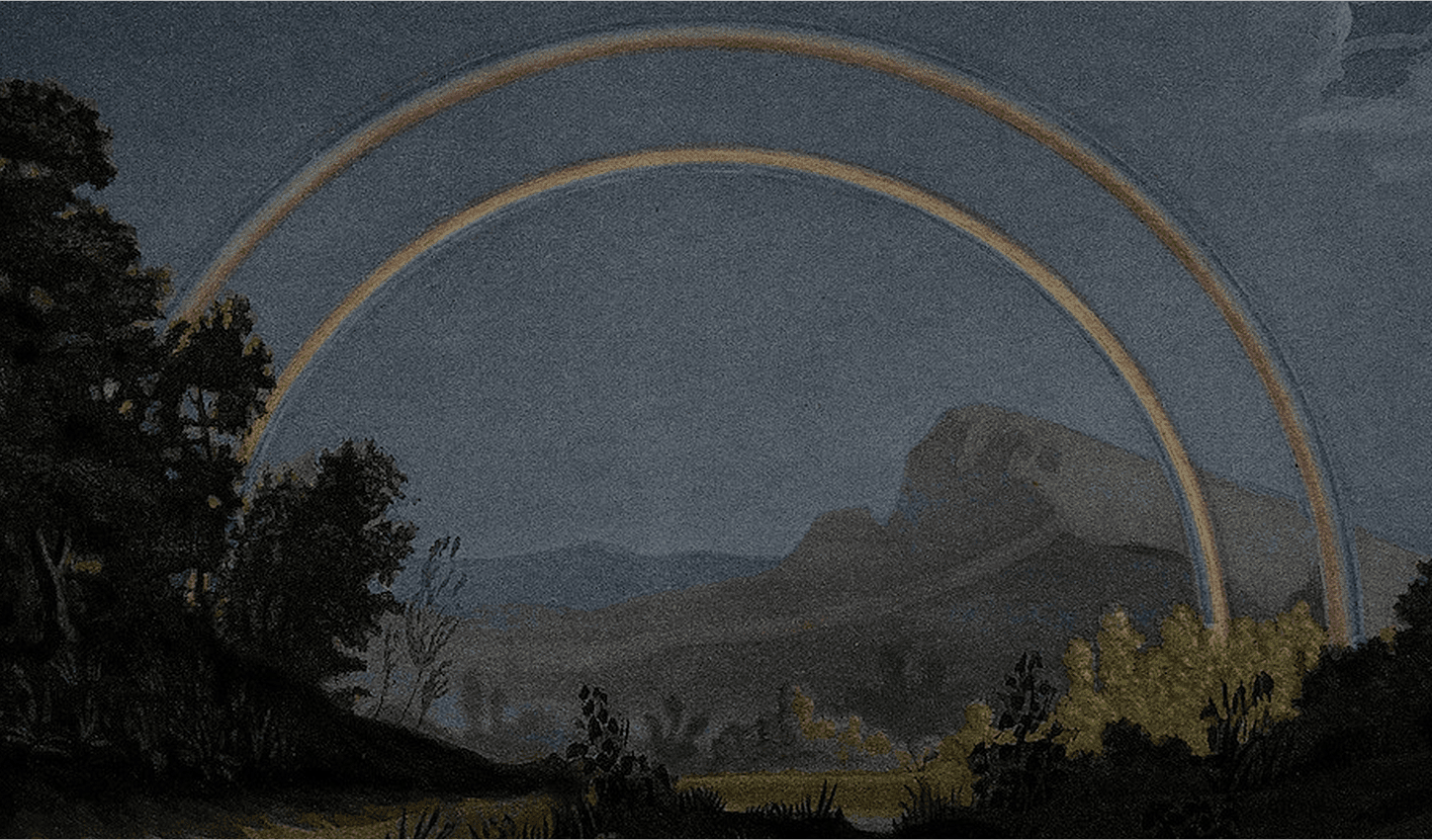 Double rainbow over a dark, moody landscape with trees in the foreground and mountains in the background.